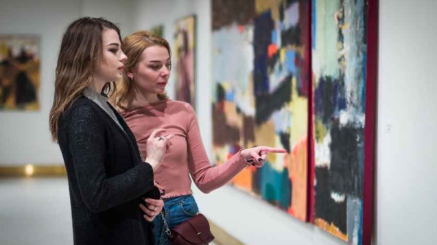 two girls stares at the pictures in the Gallery of modern art.